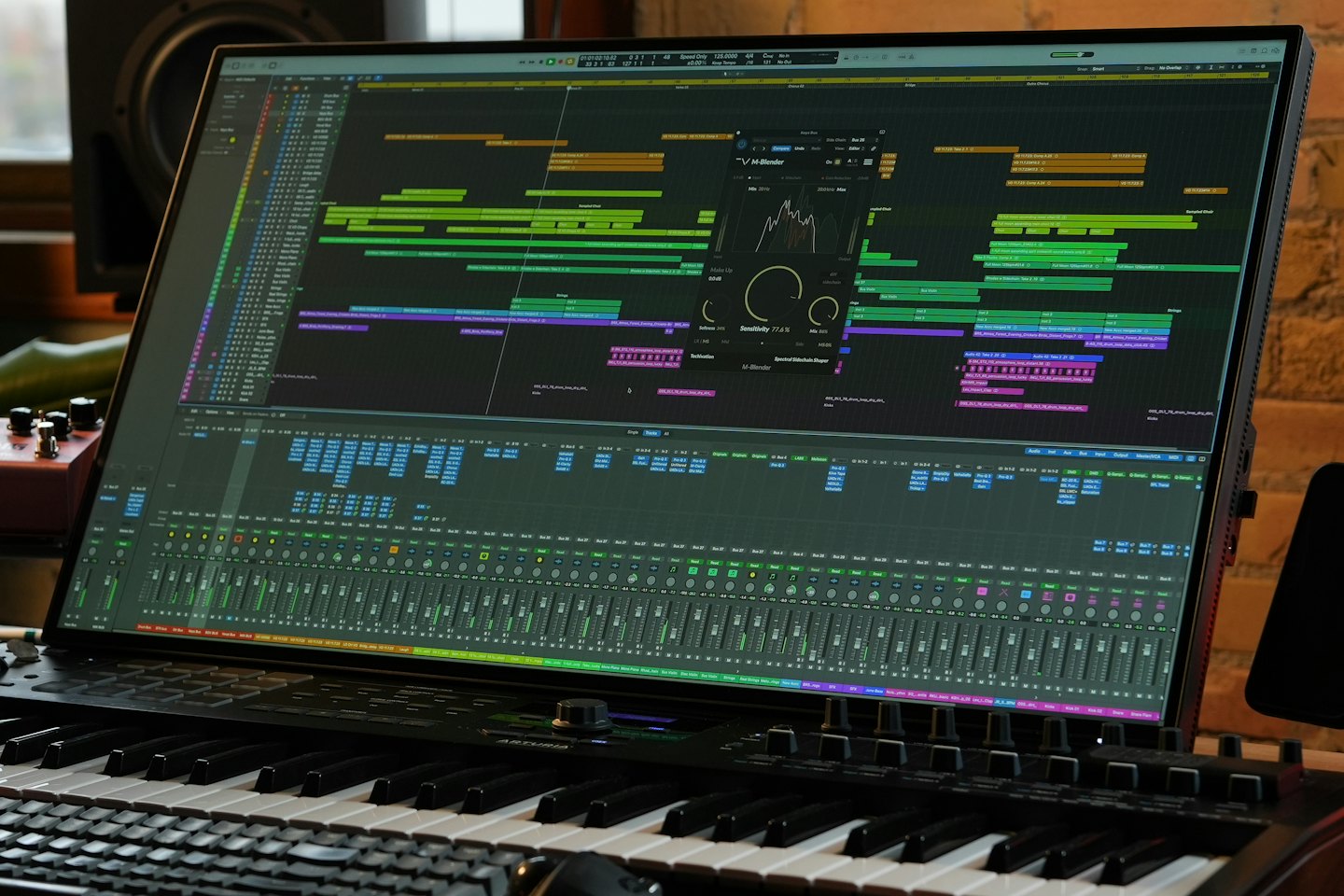 Music producer working on DAW software with MIDI keyboard.