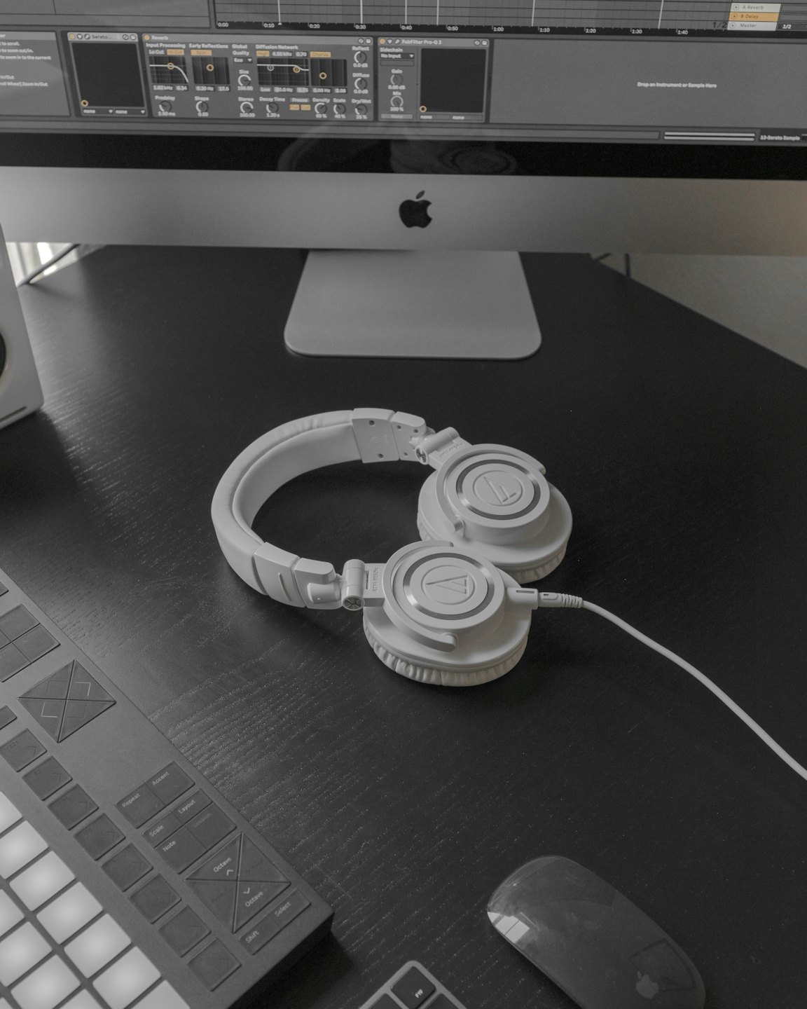 Headphones and music equipment on a dark wooden desk.