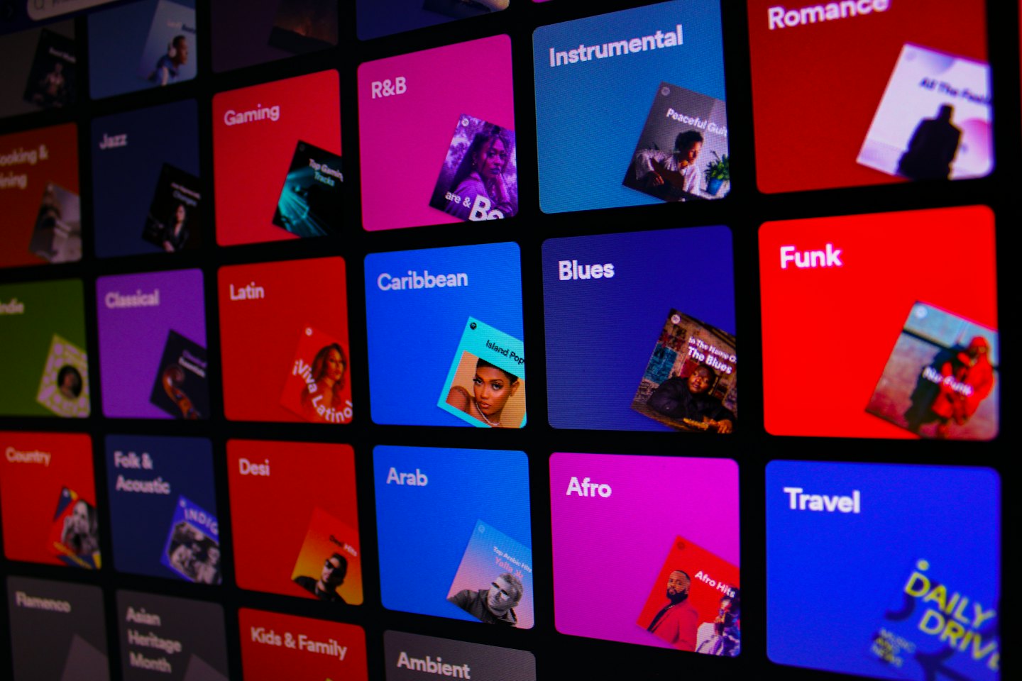 Digital screen shows colorful music genre tiles with album art.