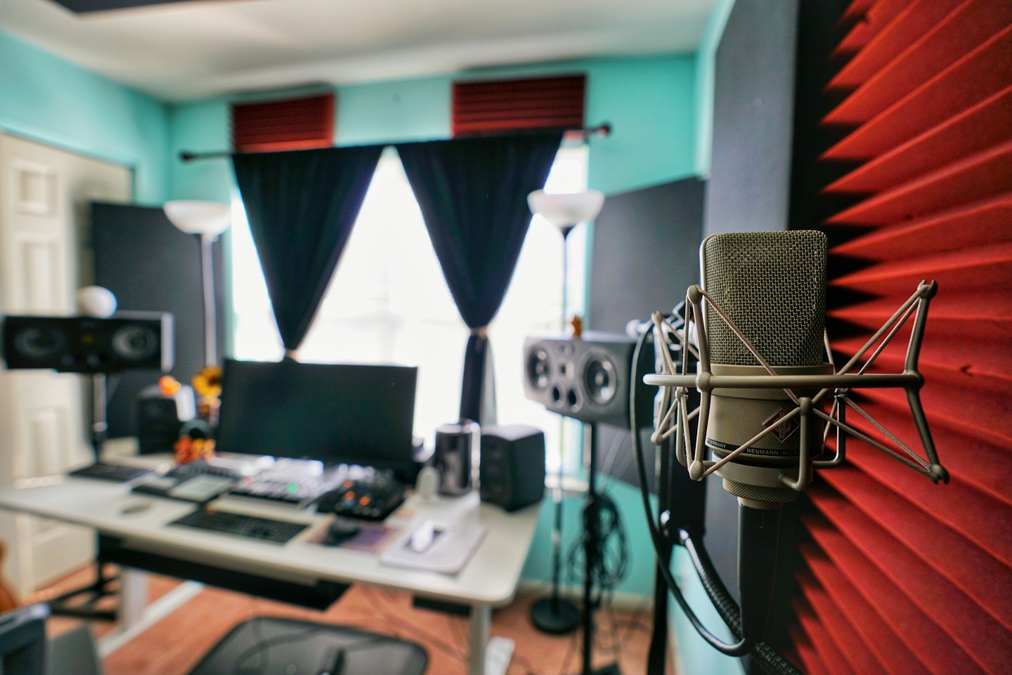 A silver Neumann microphone in a recording studio.